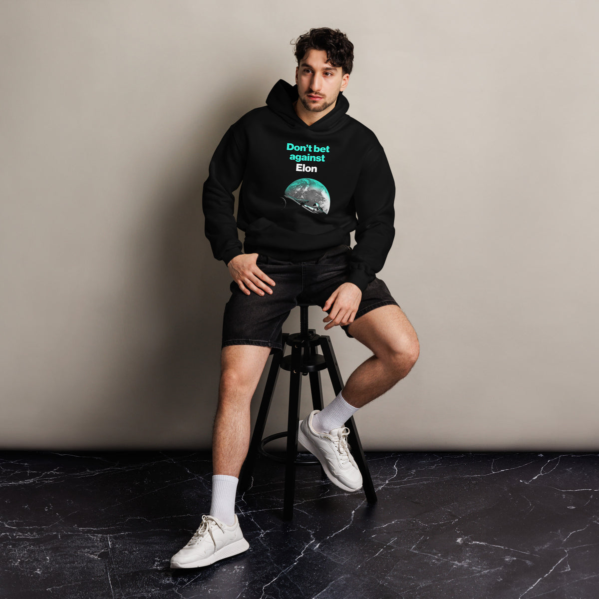 Don't Bet Against Elon Premium Hoodie unisex hoodie, black, front, seated on stool